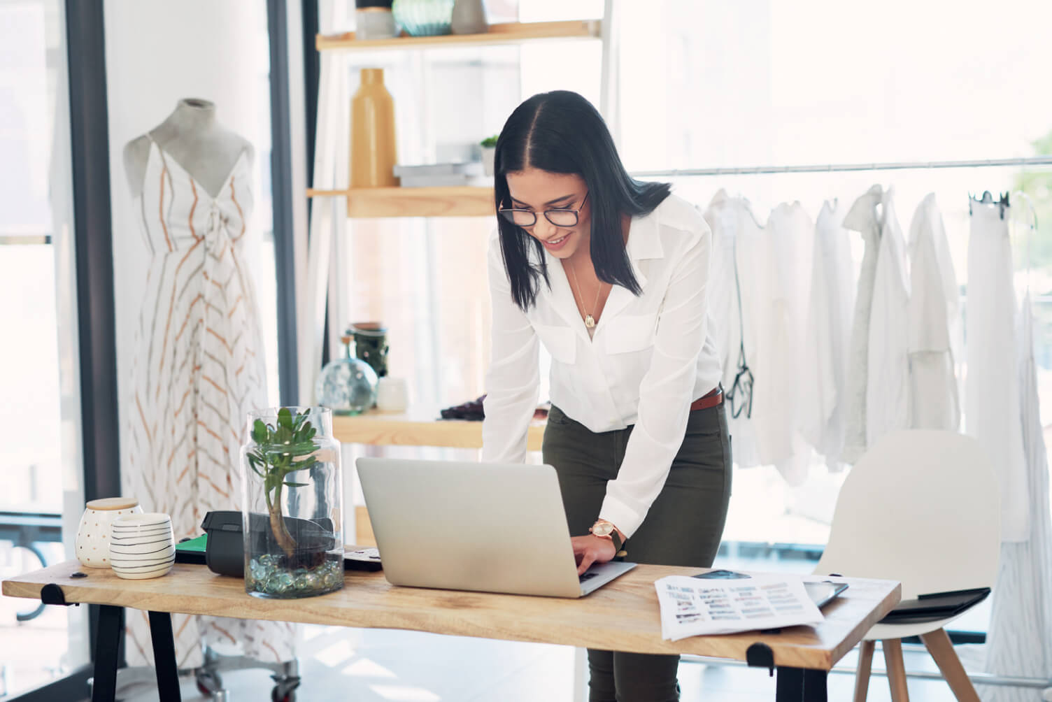 Emprendedora de textiles sonriendo con un portátil